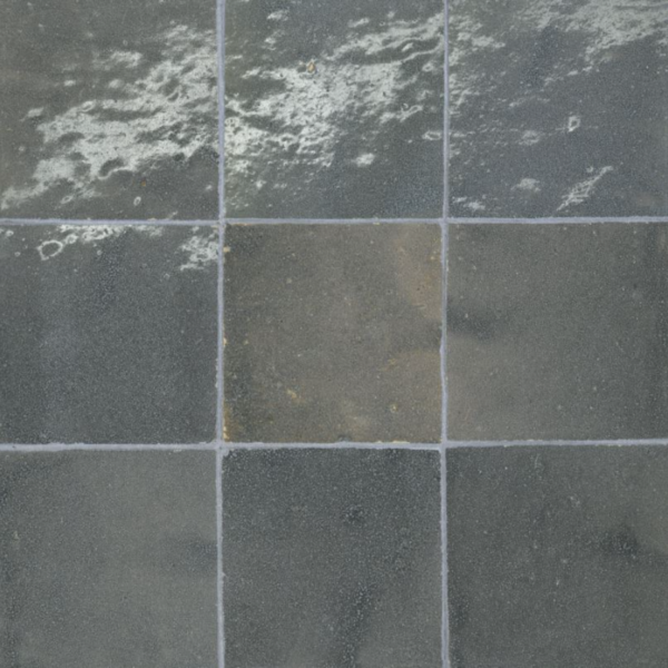 Close-up of colorful handmade Zellige tiles showcasing unique variations in color, texture, and glossy finish, highlighting Moroccan craftsmanship.