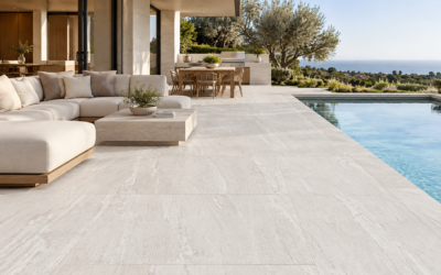 24x48 beige stone-look porcelain pavers installed on a luxury outdoor patio with modern seating, outdoor kitchen, and swimming pool.