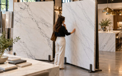 Woman comparing white dolomite and marble stone slabs in a luxury countertop showroom