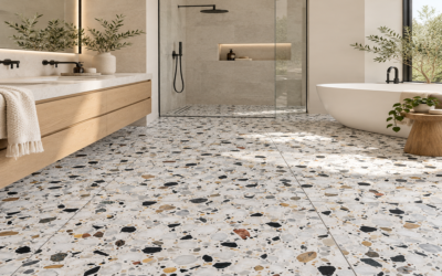 Modern luxury bathroom featuring 24x24 terrazzo floor tiles with multicolored natural stone aggregates, a floating wood vanity, glass shower, and freestanding bathtub.